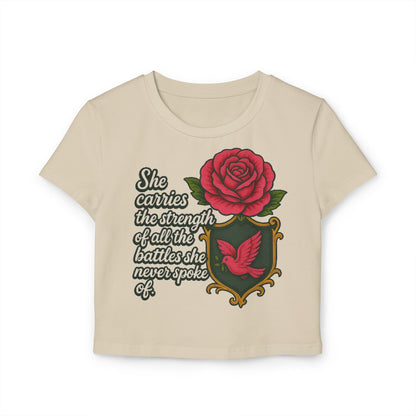 SHE CARRIES THE STRENGTH OF ALL THE BATTLES SHE NEVER SPOKE OF Women's Baby Tee
